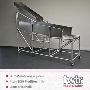Ein Kistenpuffer aus Aluprofilen. An den Seiten sind Wände aus Aluminium sowie oben eine Rutsche befestigt. Darunter steht KLT-Zuführungssystem, item D30 Profiltechnik und Sensortechnik.
