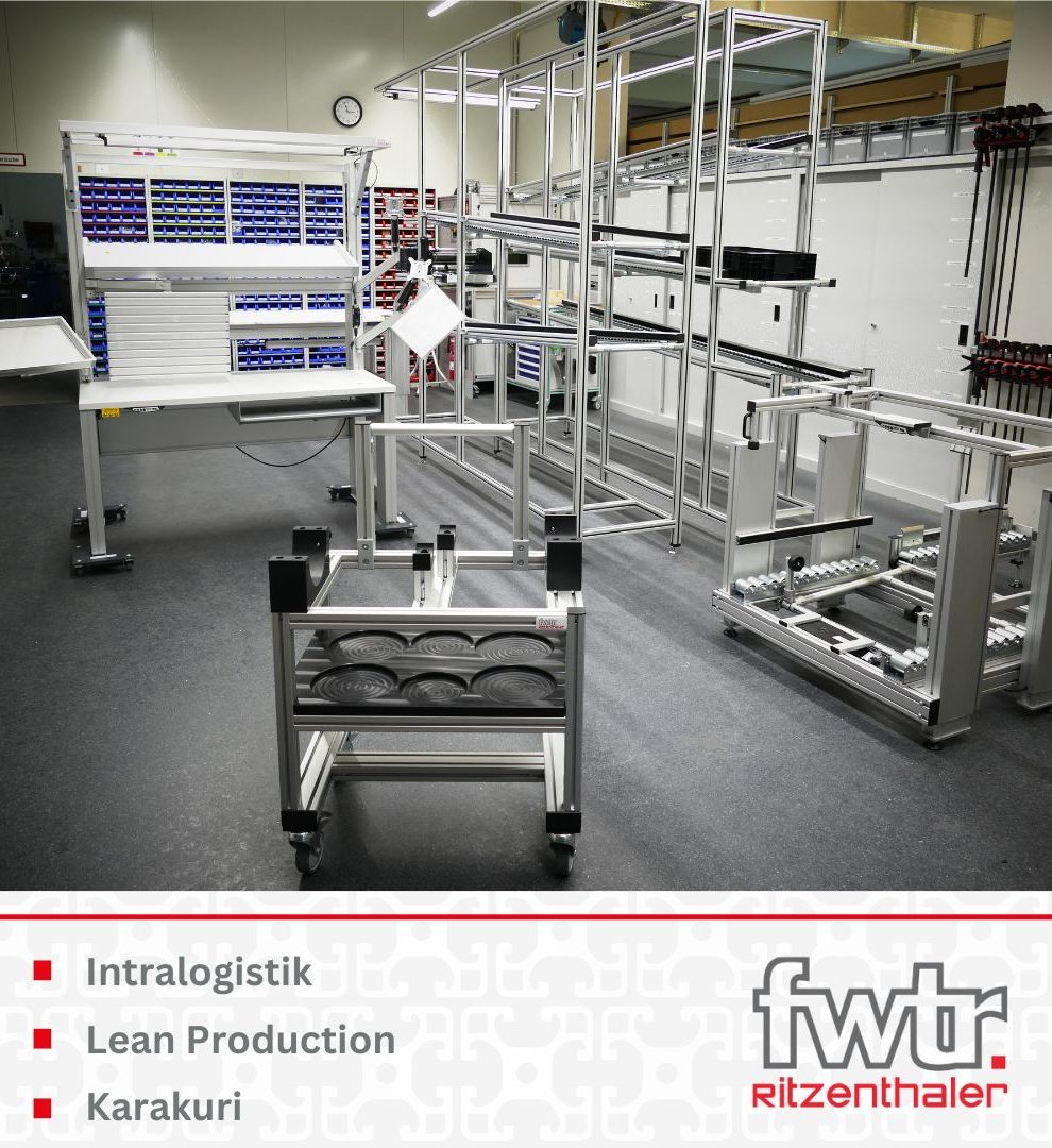 Innenansicht der FWTR Werkstatt mit einem Arbeitstisch, einem Wagen und einer Transport bahn aus Profilbautechnik. Darunter stehen die Wörter Intralogistik, Lean Production und Karakuri